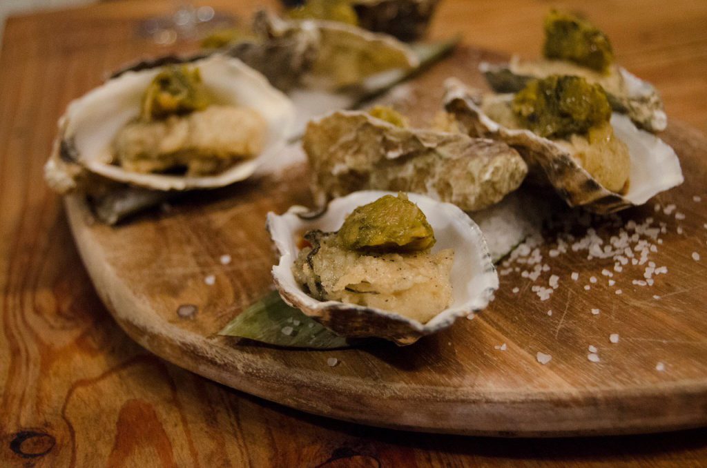 Oesters, jalapeno vinaigrette, paprika compote, houten tafel, houten plateau, zeezout, een bite of in het verrassingsmenu